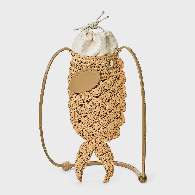 A straw-woven crossbody bag shaped like a fish with a drawstring pouch insert and leather strap.