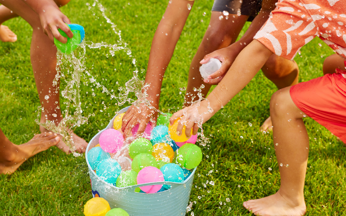 kids grabbing water balloons out of a bucket